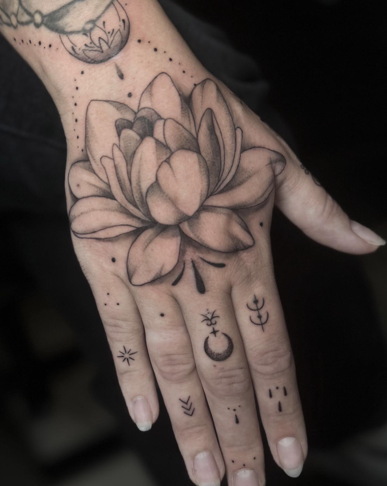 Lotusblüte auf dem Handrücken mit feinen Symbolen und Ornamenten auf den Fingern