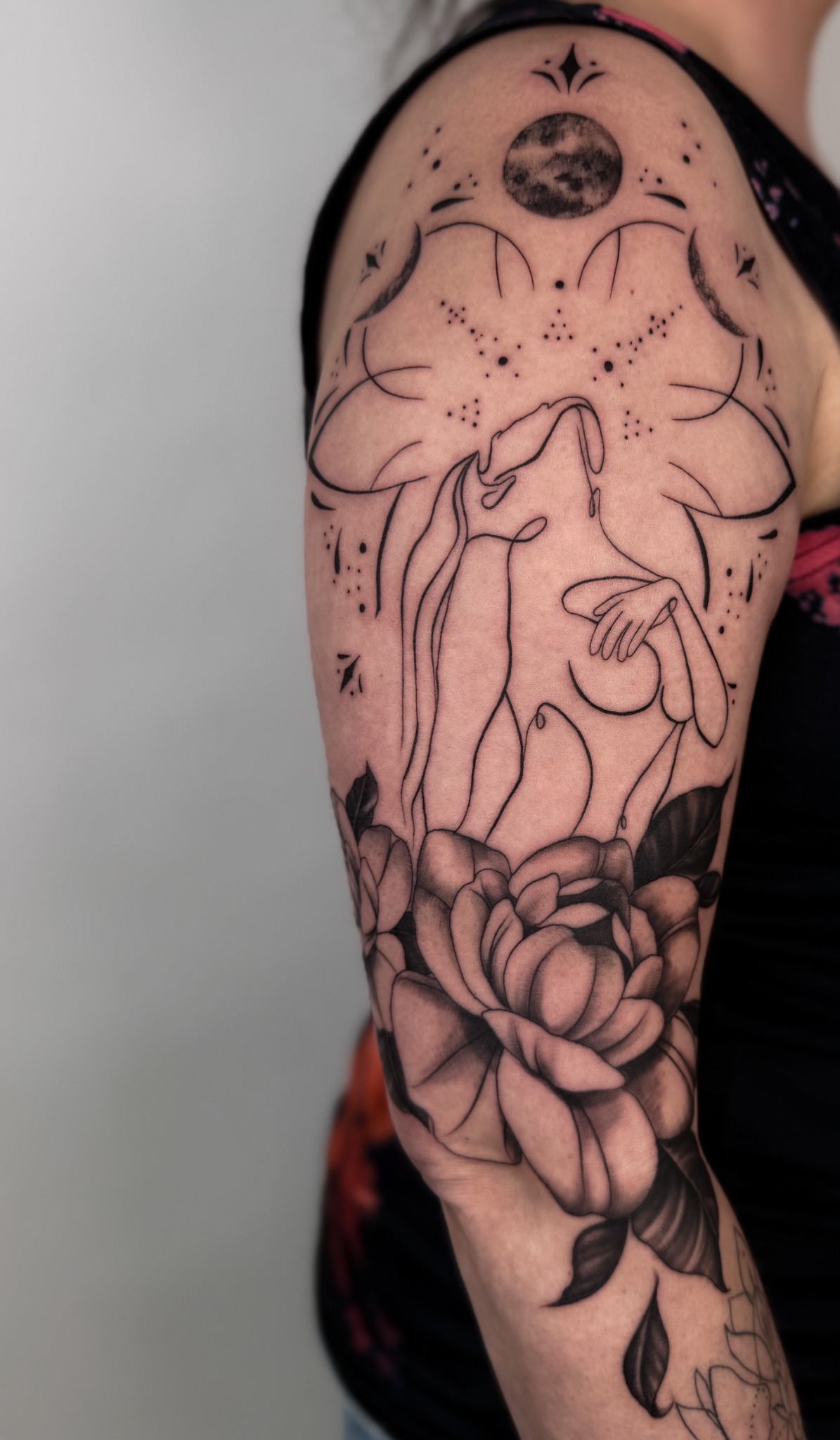 Tattoo am Arm mit Händen, Lotusblüten, Mond und ornamentalen Details