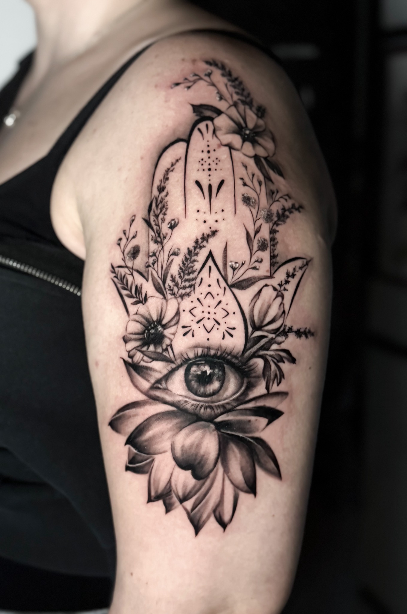 Hamsa-Motiv am Oberarm mit Auge, Blumen und ornamentalen Details
