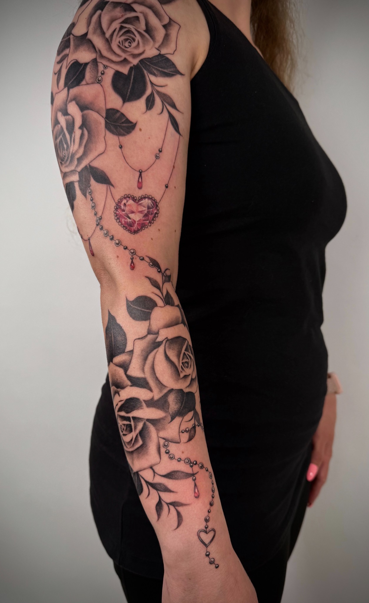 Black & Grey Tattoos am Arm mit Rosen, Blättern und feinen dekorativen Details
