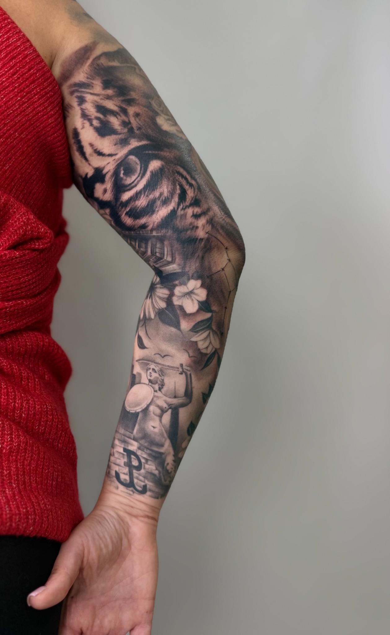 Großflächige Black & Grey Komposition am Arm mit Tierporträts und floralen Motiven