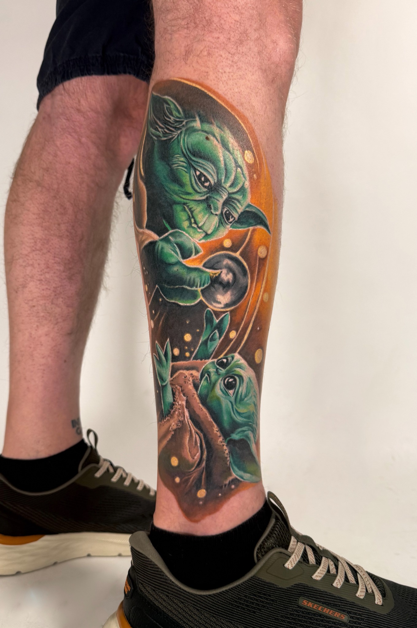 Farbiges Tattoo mit Yoda und Grogu am Unterschenkel