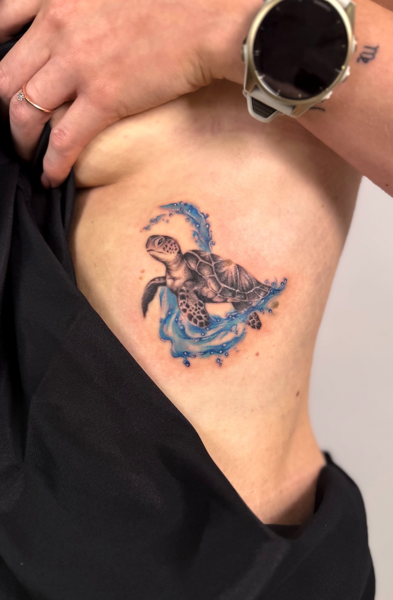 Farbiges Schildkröten-Tattoo mit blauen Akzenten an der seitlichen Rippenpartie
